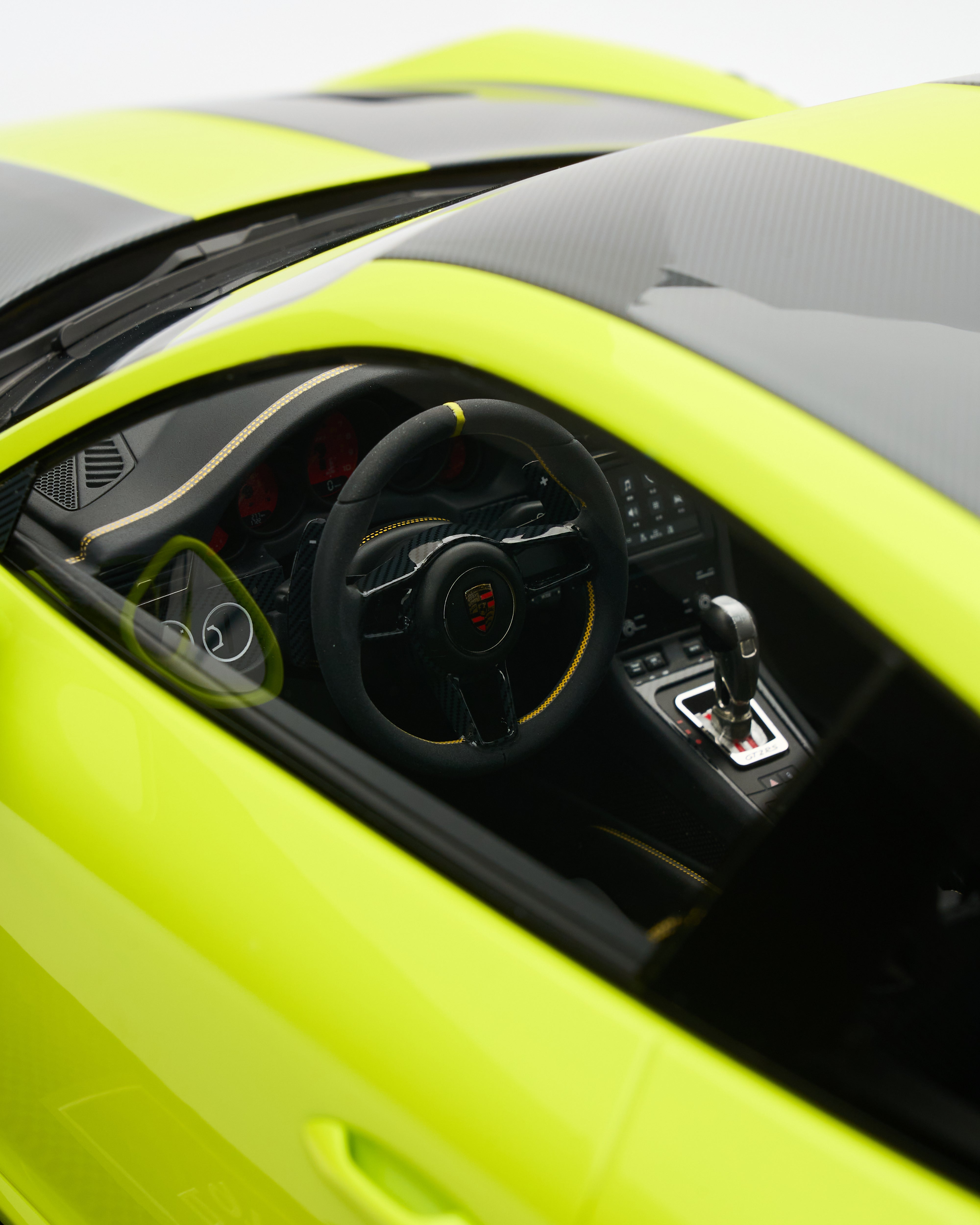 Close-up of a lime green sports car interior with steering wheel and dashboard.