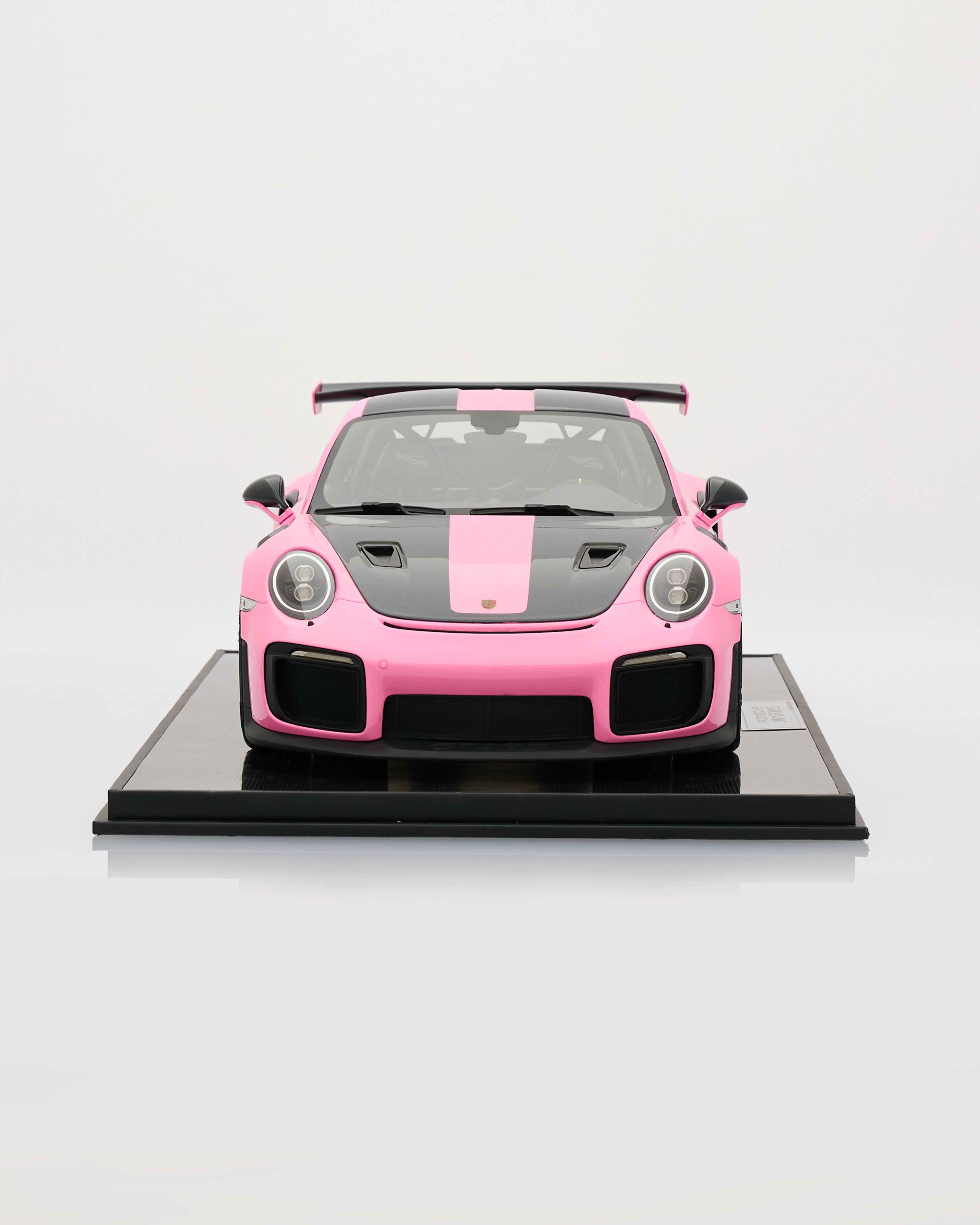Pink and black sports car model on a white background