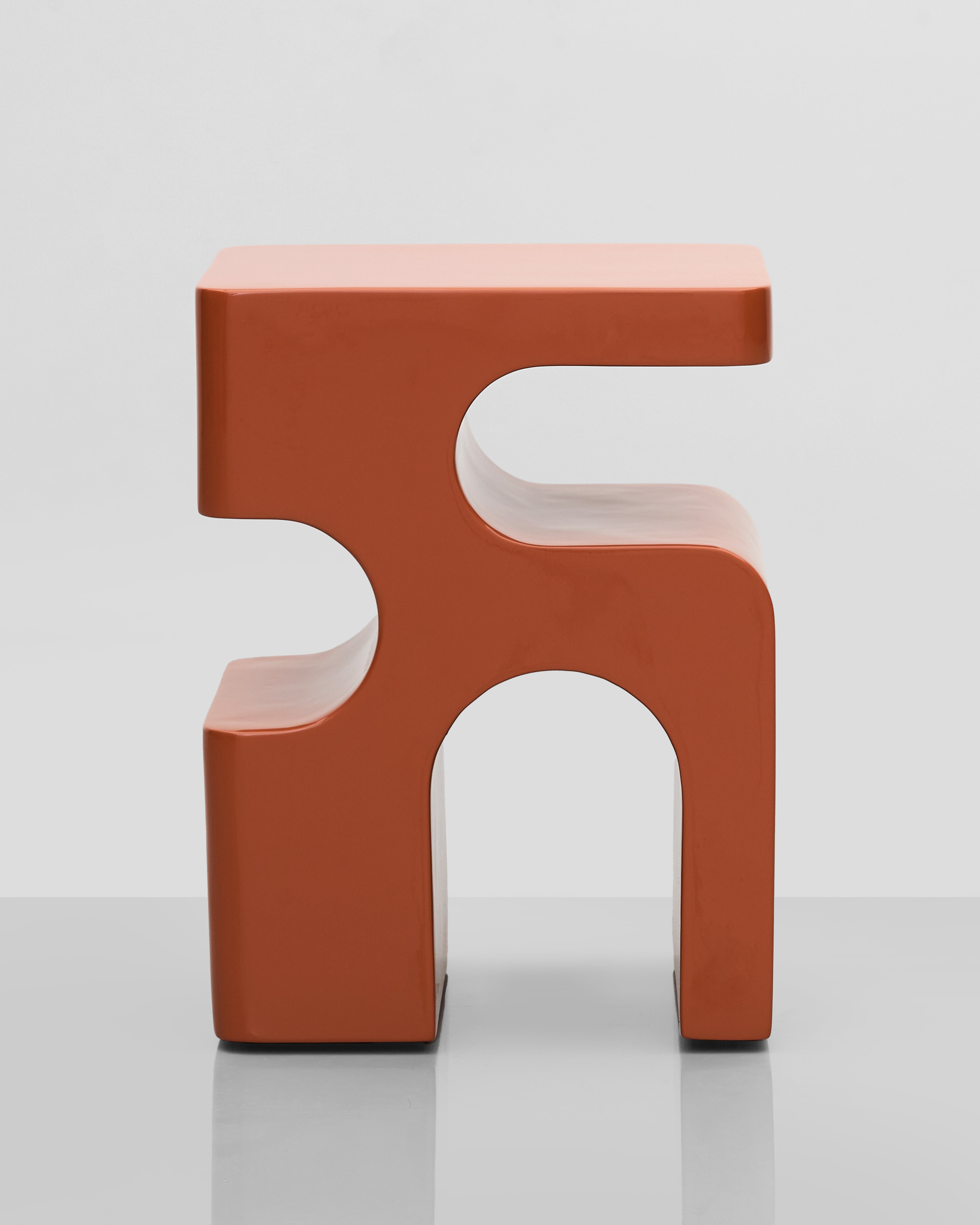 Modern orange stool with a unique design on a light gray background