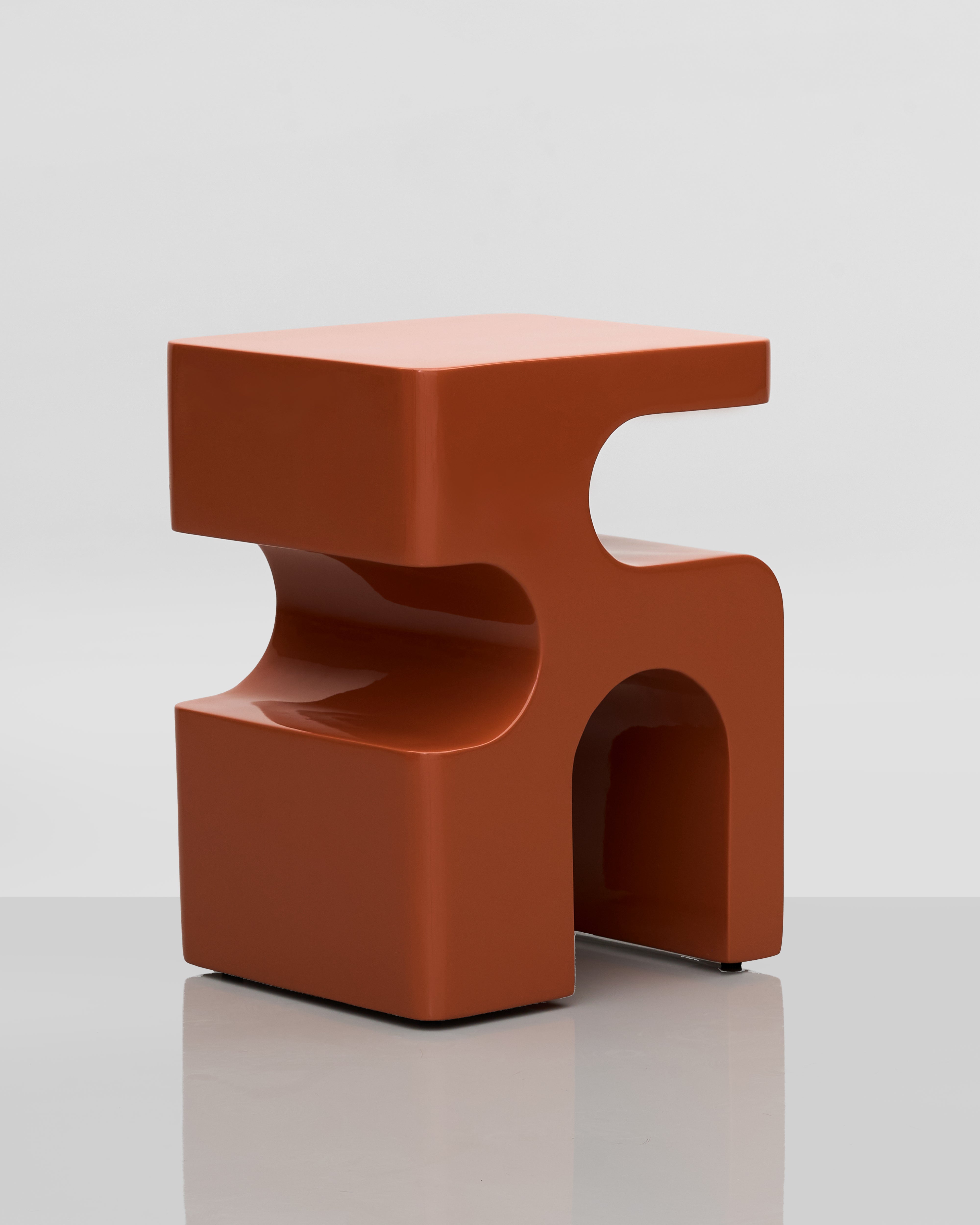 Modern orange stool with a unique design on a gray background