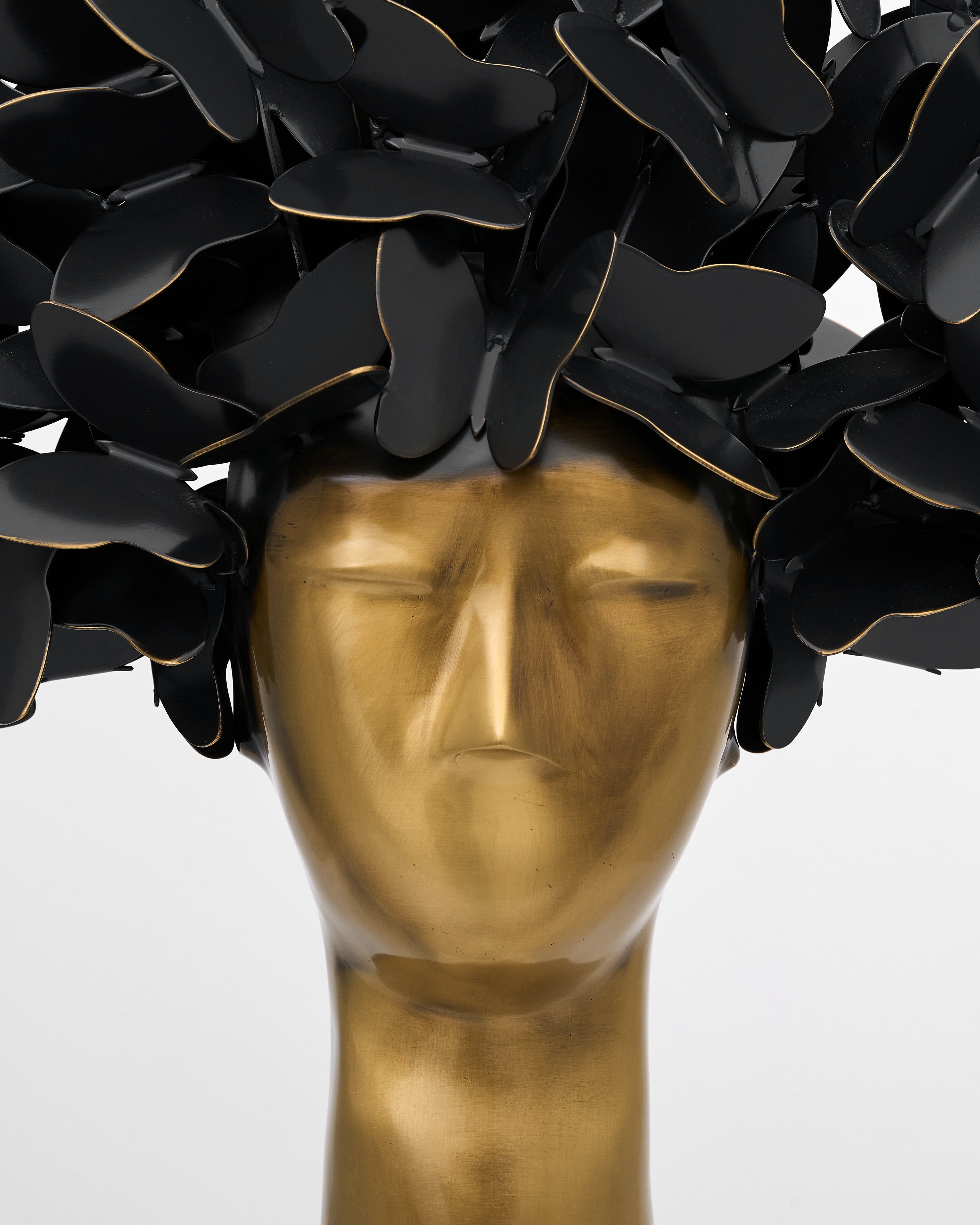 Mannequin head wearing a black floral wreath with gold accents on a white background