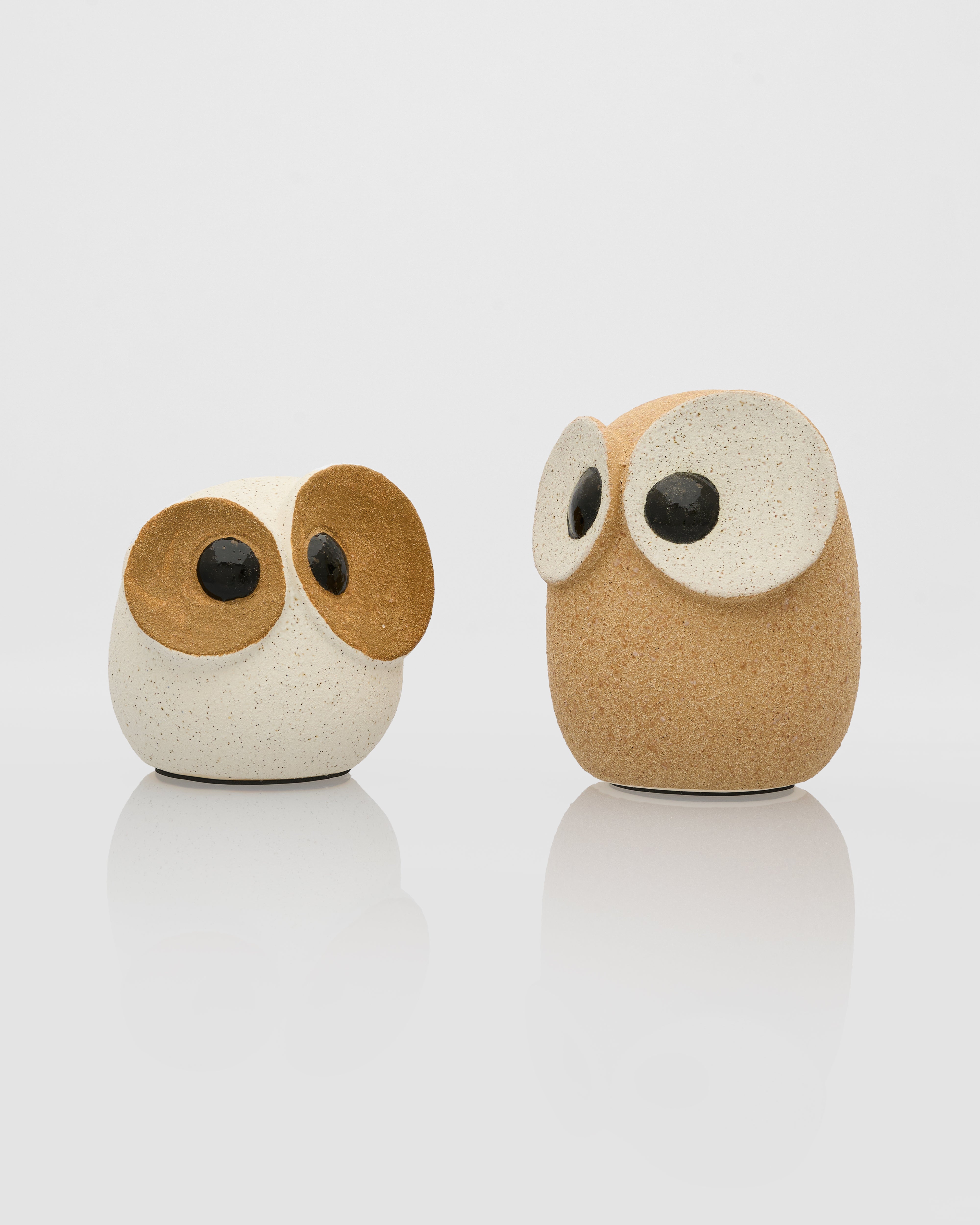 Two owl-shaped objects on a white background