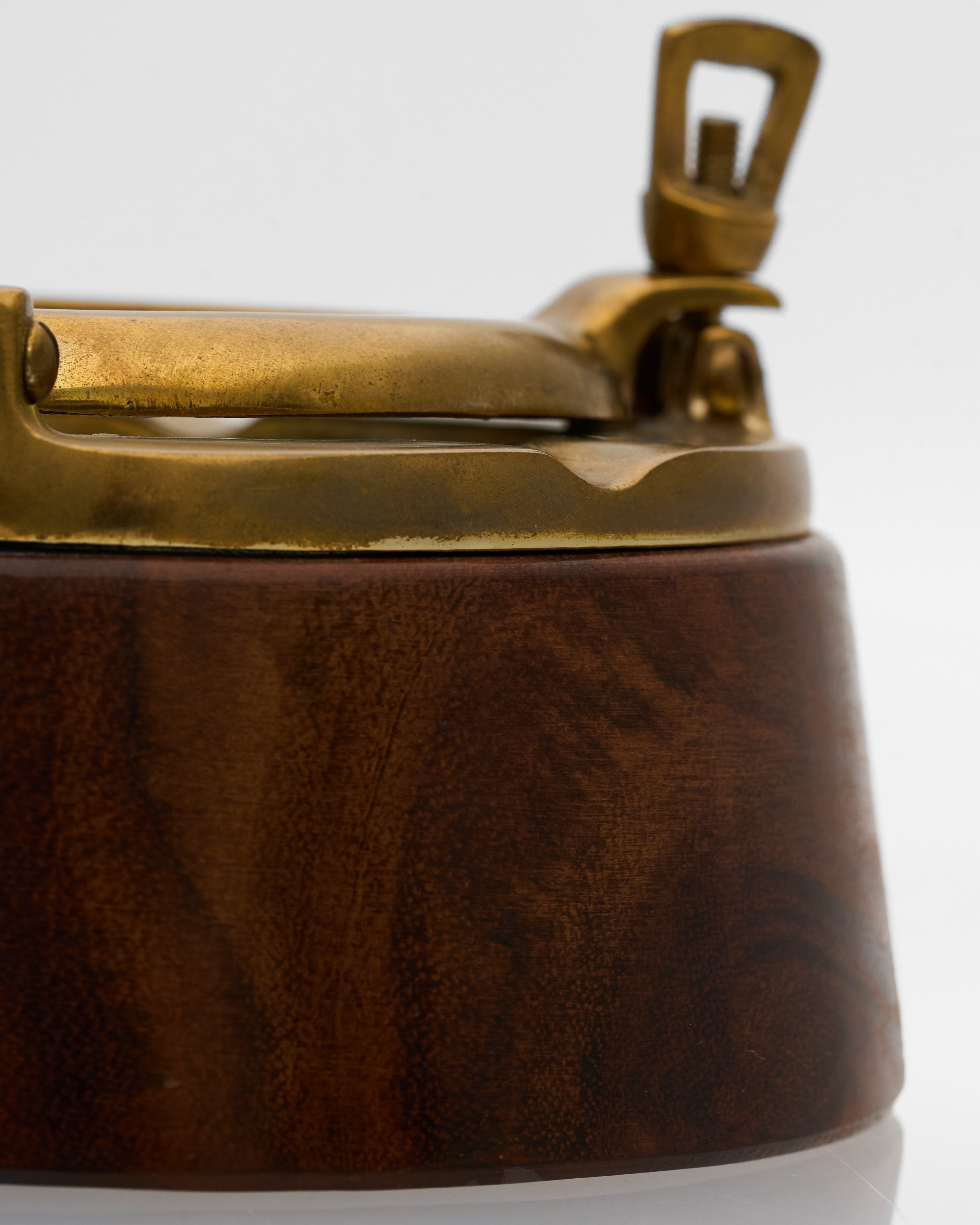 Close-up of a brass and wooden ashtray on a white background