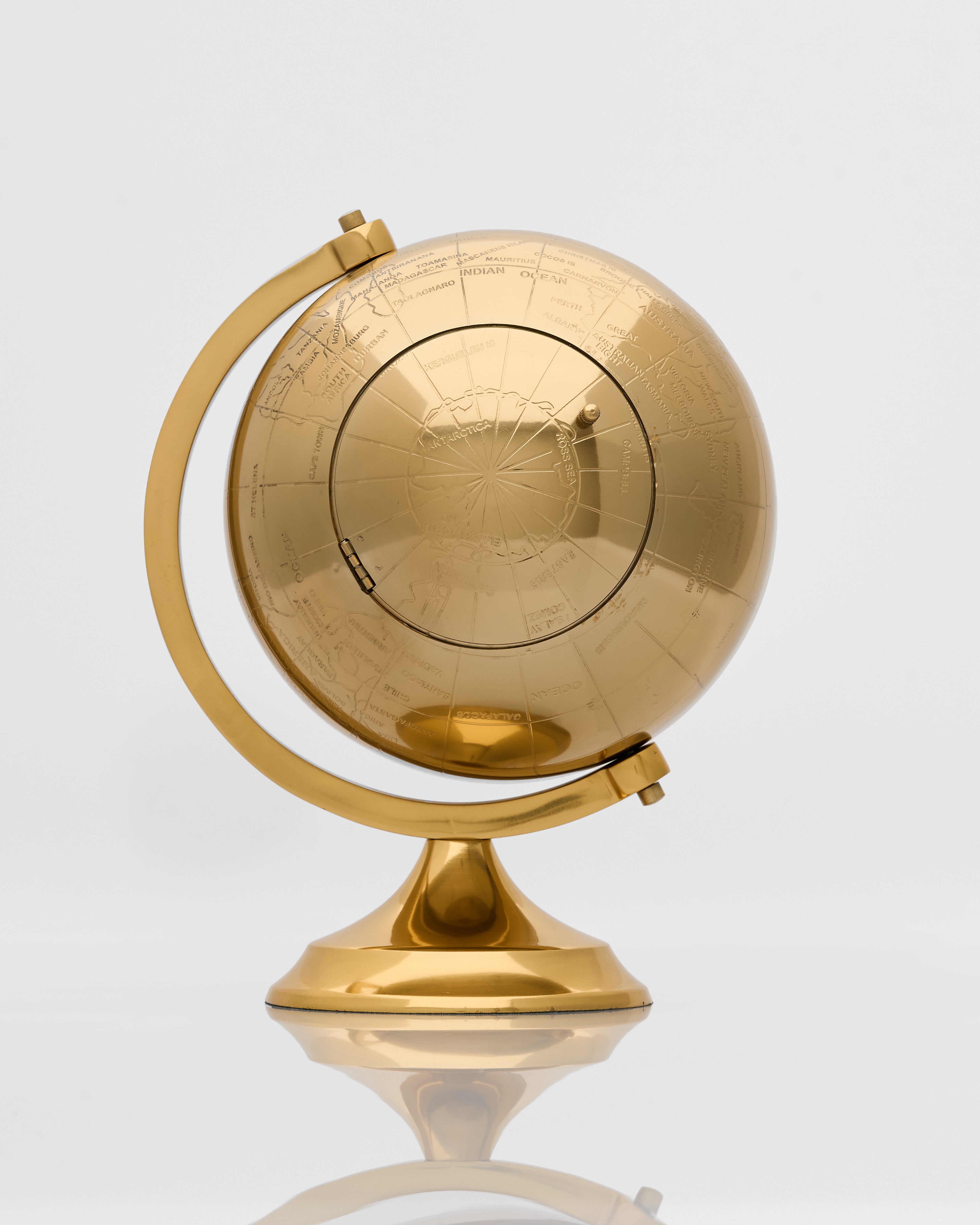Vintage globe inspired table clock angled view showcasing classic globe motif and premium decorative finish
