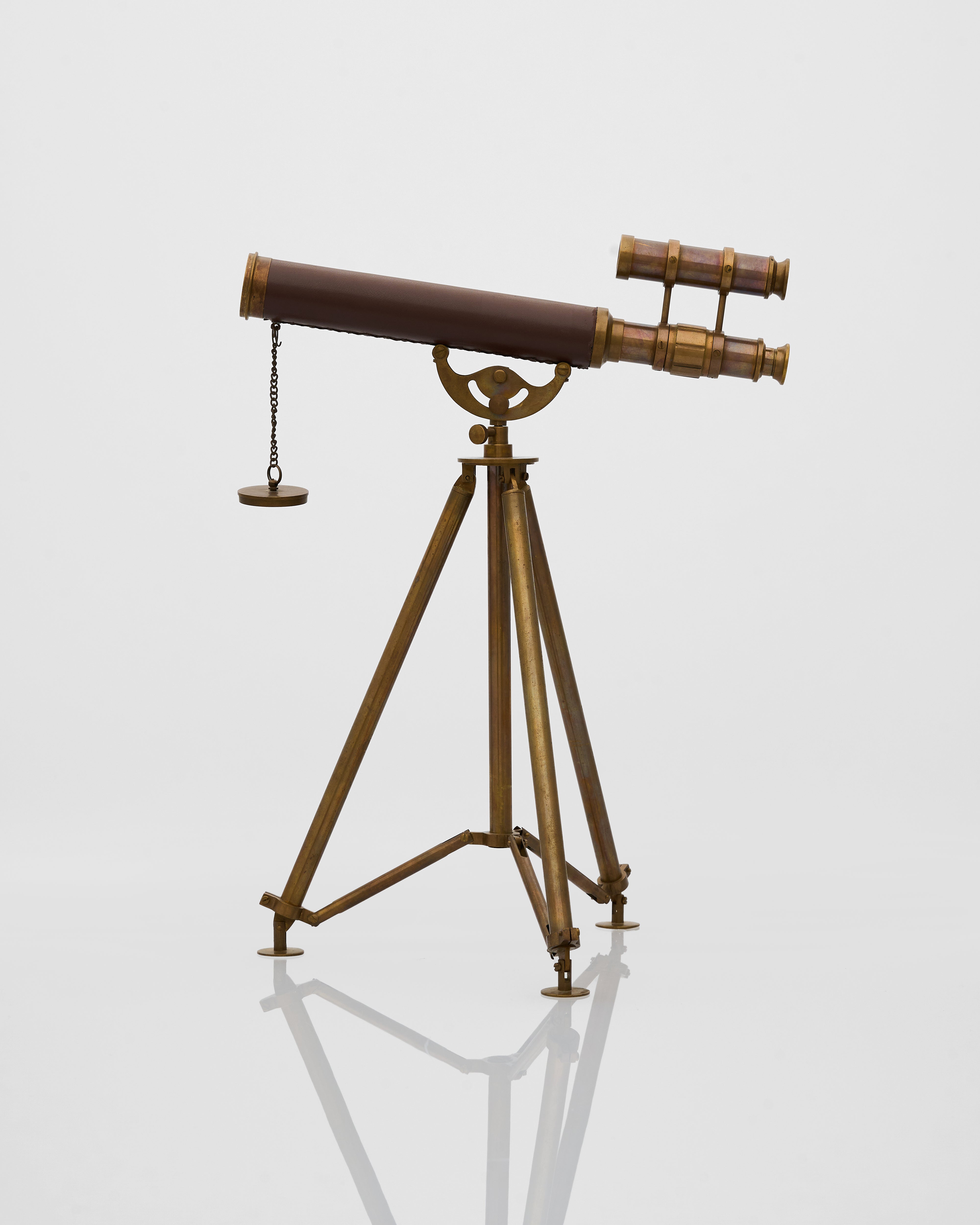 Vintage-style telescope on a stand against a light gray background